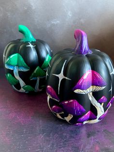 two painted pumpkins sitting on top of a table