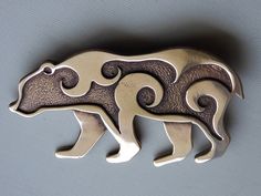 I make this bronze bear comes as either a brooch or a pendant.   The design was inspired by Pictish animals found carved on stones in Scotland.  The last picture shows an example of a bear. This is a large piece which measures 7 cm from nose to tail and is 4 cm at the shoulder. The pendant has two loops on the back for a cord or chain. It also looks great sewn on the flap of a pouch! GST is already included in the price on all Canadian sales. Statue Ideas, Bear Jewelry, Copper Uses, American Symbols, The Last Picture Show, Bear Pendant, Hood Ornaments, Spirit Animals, Ornament Ideas