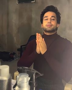 a man sitting at a table with his hands together