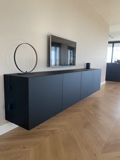 a flat screen tv mounted to the side of a wall next to a wooden floor