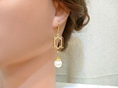 "Offering a gorgeous pair of gold classic Art Deco style pearl dangle earrings. Earrings hang down just under 2 1/4 inches (5.7 cm) from the top of the ear wire; pearls are 12mm in diameter. These feature satiny vintage simulated light ivory pearls topped with an ornate bead cap and suspended from high quality gold colored brass classic Art Deco shaped pieces. I've been offering these in silver for a while and decided to offer in gold as well. I just love how these turned out! SO 1920s flapper. Classic Gold Bridal Earrings For Party, Yellow Gold Pearl Bridal Earrings For Wedding, Gold Classic Bridal Earrings For Party, Yellow Gold Pearl Charm Bridal Earrings, Wedding Yellow Gold Pearl Charm Bridal Earrings, Elegant Gold Dangle Bridal Earrings, Yellow Gold Bridal Earrings With Pearl Charm, Art Deco Gold Dangle Bridal Earrings, Art Deco Gold Drop Bridal Earrings