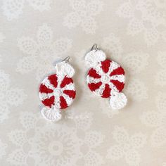 two red and white crocheted candy canes on a lace doily background