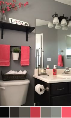 a white toilet sitting under a bathroom mirror next to a pink towel hanging on the wall