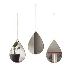 three tear shaped mirrors hanging from chains, one with a potted plant in it