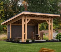 a small wooden shed sitting on top of a lush green field