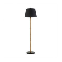 a floor lamp with a black shade on the base and a wooden stick in front of it