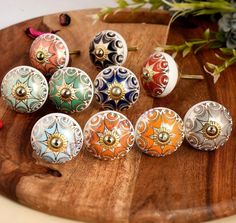 seven decorative door knobs on a wooden board