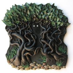 an intricately designed clock with trees and rocks