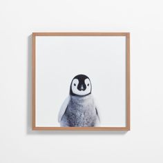 a small penguin with black and white spots on it's face is mounted in a wooden frame