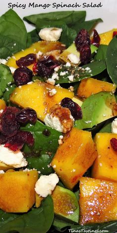 spinach salad with oranges, cranberries and feta cheese on top