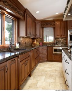 a kitchen with wooden cabinets and marble counter tops