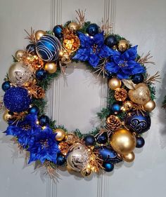 a christmas wreath with blue and gold ornaments