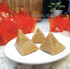 three pieces of peanut butter on a white plate with red bags in the back ground