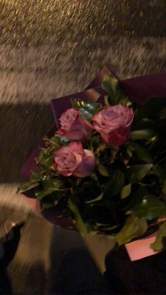 a bouquet of pink roses sitting on top of a table