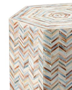 a multicolored wooden box sitting on top of a white surface with an intricate design