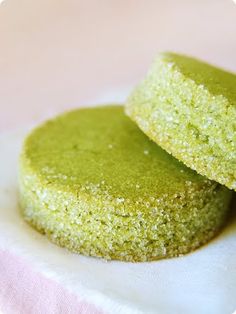 two green cookies sitting on top of a white napkin