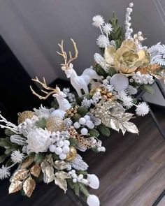 a white and gold floral arrangement in a vase