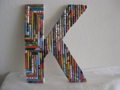 the letter k is made out of books and has been placed in front of a white wall