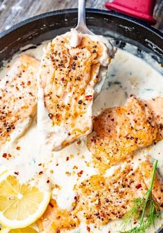 salmon with lemon sauce in a skillet on a wooden table