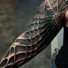 a man's arm is covered in black and grey ink with an intricate design