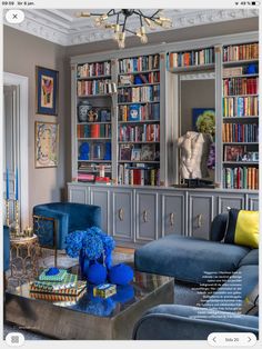 a living room filled with furniture and bookshelves covered in lots of bookcases