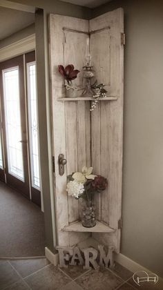 an old door is used as a shelf for vases and flowers in the entryway