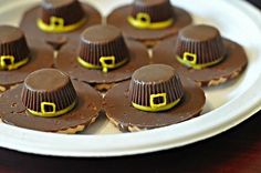 there are many small chocolates with hats on them sitting on a white platter