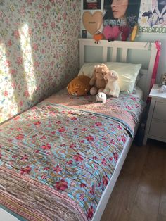 there is a bed with two stuffed animals on it