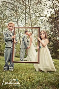 a young boy and girl standing in front of a mirror with their reflection on it