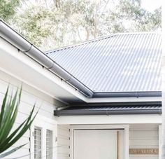 a white house with a potted plant on the front porch and a sign that says welcome to australia