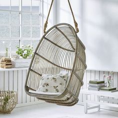 a swing chair hanging from the ceiling in a room with white walls and flooring