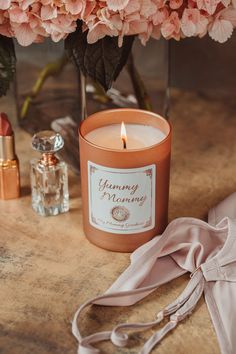 a candle and some pink flowers on a table