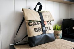 a backpack sitting on top of a counter next to a potted plant and coffee maker