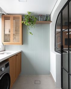 a washer and dryer in a small room with wooden cabinets on the wall