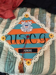 a graduation cap with the word usoc on it sitting on top of a bed