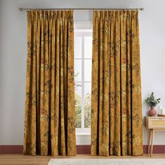 a living room with yellow curtains and a white rug in front of the window on top of a wooden floor