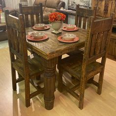 a wooden table with chairs and plates on it