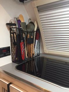 kitchen utensils are stored on the shelf above the stove