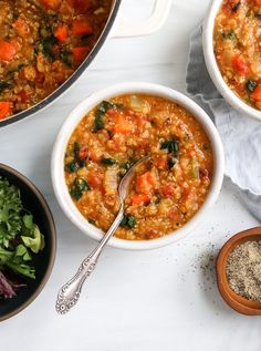 three bowls filled with soup next to a bowl of salad