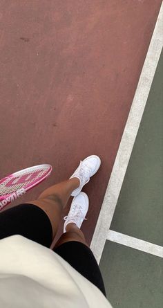 a person standing on top of a tennis court holding a racquet in their hand