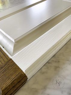 a close up view of a white door frame with wood graining on the bottom