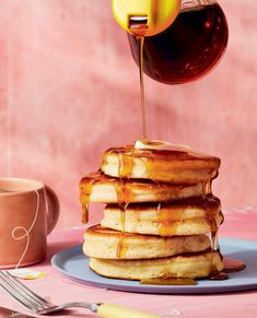 a stack of pancakes with syrup being drizzled over them