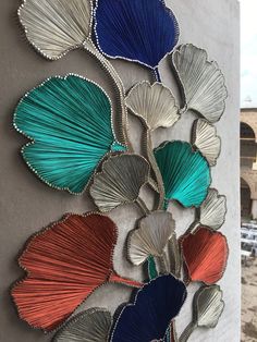 a wall hanging with many different colored shells on it