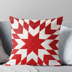 a red and white quilted pillow on a couch