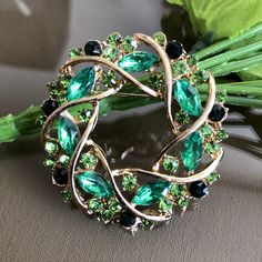 Green crystal rhinestone wreath brooch pin Height: 1.8 inch ( 4.6cm ) Width: 1.8 inch ( 4.6 cm ) Condition: Vintage condition Found in: The Netherlands Material: Green color crystal, rhinestone, metal Please know that the items for sale in my shop are vintage pre-owned items, not in their original condition and may show signs of wear due to age and use. There may be minor flaws such as light scuffs, tarnish, color fade, scratches, etc. View the photos to evaluate the condition Your item will be Green Round Brooch Jewelry, Green Round Brooch, Green Crystal Brooch Jewelry, Green Round Brooches For Wedding, Green Round Wedding Brooches, Rhinestone Wreath, Green Brooch, Vintage Rhinestone Brooch, Floral Jewelry