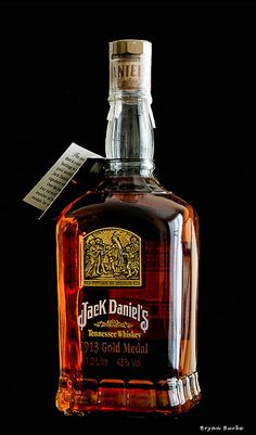 a bottle of jack daniels tennessee whiskey with a note on it's label sitting in front of a black background