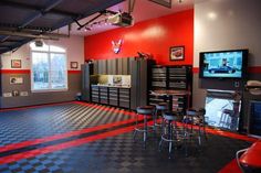 a garage with checkered flooring and red walls is shown in this image, there are several storage cabinets on the far wall