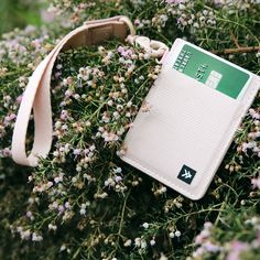 a small white wallet sitting on top of some flowers