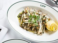 a white plate topped with lots of food next to silverware and glasses on a table