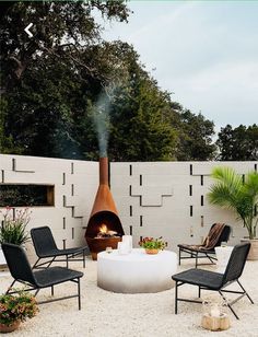 an outdoor fire pit with chairs around it